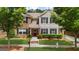 Charming home with a well-manicured lawn, an American flag, shutters, and red front door at 397 Cypher Dr, Suwanee, GA 30024