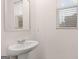 Elegant bathroom featuring a sleek pedestal sink with modern fixtures and a decorative mirror at 352 Sound Cir, Stockbridge, GA 30281
