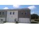 New townhomes with white and gray siding, two-car garages, and well-maintained landscaping at 352 Sound Cir, Stockbridge, GA 30281