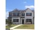 New two-story townhome with brick base, grey and white paint, black shutters and well-manicured lawn at 352 Sound Cir, Stockbridge, GA 30281