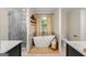 Bright bathroom features a soaking tub under a window, complemented by a spacious shower and stylish floating shelves at 4645 Villa Ridge Ne Rd, Marietta, GA 30068