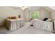 Comfortable bedroom featuring two beds, a ceiling fan, and a window that offers a view of the outdoor landscape at 4645 Villa Ridge Ne Rd, Marietta, GA 30068