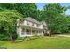Lovely two-story home featuring a spacious front porch and lush green lawn with mature trees at 4645 Villa Ridge Ne Rd, Marietta, GA 30068