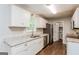 Well-lit kitchen featuring stainless steel appliances, granite countertops, and classic white cabinets at 64 Acorn Dr, Dallas, GA 30157