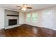 Inviting living room with a striking gray brick fireplace, wood floors, and bright windows at 64 Acorn Dr, Dallas, GA 30157