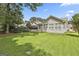 Backyard featuring a lush lawn, manicured landscaping and an enclosed sunroom at 2118 Cherry Tree Ln, Peachtree City, GA 30269
