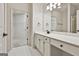 Bright bathroom showcasing a vanity with sleek hardware, large mirror, and access to a walk-in closet at 2118 Cherry Tree Ln, Peachtree City, GA 30269