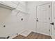 Laundry room featuring built-in shelving, wood flooring, and a white door at 2118 Cherry Tree Ln, Peachtree City, GA 30269