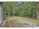 View of the serene backyard and back deck from a wooden deck, surrounded by mature trees at 270 Carrolls Way, Fayetteville, GA 30215