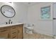Bathroom features wood vanity, framed round mirror and white fixtures at 270 Carrolls Way, Fayetteville, GA 30215