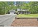 Exterior view showcasing home and detached garage with paved driveway and wraparound porch at 270 Carrolls Way, Fayetteville, GA 30215