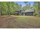 Charming home exterior featuring a large wooden deck surrounded by lush greenery at 270 Carrolls Way, Fayetteville, GA 30215