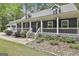 Charming home's front porch with white railings, well-kept landscaping, and a mix of greenery and stone accents at 270 Carrolls Way, Fayetteville, GA 30215
