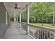 Spacious covered porch with white railings and views of the surrounding wooded landscape and lush greenery at 270 Carrolls Way, Fayetteville, GA 30215