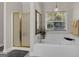 Bright bathroom with a bathtub, separate shower, and chandelier at 1120 Upchurch Rd, Mcdonough, GA 30252