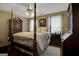 Bedroom features a four-poster bed, hardwood floors, and soft, natural lighting at 1120 Upchurch Rd, Mcdonough, GA 30252