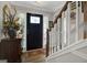 Foyer with wood floors, elegant staircase, and black front door with decorative glass at 1120 Upchurch Rd, Mcdonough, GA 30252