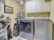 Functional laundry room equipped with a washer, dryer, and storage cabinets at 1120 Upchurch Rd, Mcdonough, GA 30252