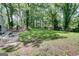 Large backyard with lush green grass and mature trees at 405 Abbey Rd, Peachtree City, GA 30269