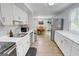 Kitchen with stainless steel appliances and white cabinets, looking out to a view of the dining room at 405 Abbey Rd, Peachtree City, GA 30269