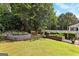 Beautiful backyard with a garden bed, a bench, a brick water feature, and lush green landscaping and a picket fence at 105 Roxbrough Ln, Fayetteville, GA 30215