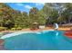 Large backyard pool with a slide, lounge area, and meticulously maintained landscaping, perfect for outdoor enjoyment at 105 Roxbrough Ln, Fayetteville, GA 30215