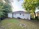 A view of the backyard featuring a white painted brick home with a stone fire pit at 2103 Keheley Dr, Decatur, GA 30032