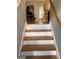 Stairway leading to kitchen and dining area with light-colored wood floors and natural light at 120 Alfred Dr, Carrollton, GA 30116