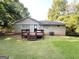 View of back of house with small deck and lawn at 3456 Spring Cir, Decatur, GA 30032