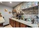 Basement bar with granite countertop, wooden cabinets, and shelving for bottles and glassware at 1492 Bourdon Bell Se Dr, Conyers, GA 30013