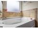 Close-up of the elegant and pristine soaking tub, complete with tile accents, offering a tranquil retreat at 1492 Bourdon Bell Se Dr, Conyers, GA 30013