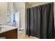 Bathroom with single vanity, toilet, and shower with a black shower curtain at 1492 Bourdon Bell Se Dr, Conyers, GA 30013