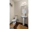 Cozy powder room with pedestal sink, dark wood floors, and a charming ambiance at 1492 Bourdon Bell Se Dr, Conyers, GA 30013