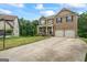 Well-manicured house showcasing an attached two-car garage, brick facade, and covered entryway at 1492 Bourdon Bell Se Dr, Conyers, GA 30013