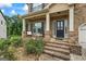 Covered front porch with brick steps and decorative seating, with black shutters at 1492 Bourdon Bell Se Dr, Conyers, GA 30013
