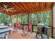 Enjoy outdoor living on this screened porch, with comfortable seating and cooking area, overlooking lush greenery at 1492 Bourdon Bell Se Dr, Conyers, GA 30013