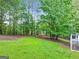 Expansive backyard featuring a wooded area with fire pit and a grassy lawn at 394 Thornbrooke Dr, Hiram, GA 30141