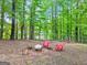 Wooded backyard with a fire pit area and red Adirondack chairs for relaxation at 394 Thornbrooke Dr, Hiram, GA 30141