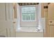 Bright bathroom with a large soaking tub, window, and decorative wallpaper at 4135 Coursey Lake Rd, Douglasville, GA 30135