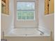 A soaking tub is positioned under a window with views of nature at 4135 Coursey Lake Rd, Douglasville, GA 30135