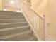 Carpeted staircase with white railing, offering a seamless transition between levels at 4135 Coursey Lake Rd, Douglasville, GA 30135