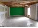 Unfinished basement with exposed ceiling and a bright green accent wall at 2225 Blue Ridge Ln, Conyers, GA 30012
