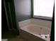 Bright bathroom featuring a soaking tub with white tile backsplash and a window at 2225 Blue Ridge Ln, Conyers, GA 30012