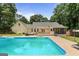 Beautiful backyard with a pool, trees, manicured lawn and a yellow house at 537 Country Lake Dr, Mcdonough, GA 30252