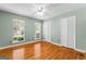 Bedroom with hardwood floors, two windows, neutral paint, ceiling fan and white closet doors at 537 Country Lake Dr, Mcdonough, GA 30252