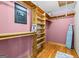 Organized closet with wooden shelves, hanging rods, and a personal safe at 537 Country Lake Dr, Mcdonough, GA 30252