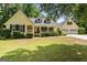 Charming yellow home featuring a lush front yard, covered porch, and an attached two car garage at 537 Country Lake Dr, Mcdonough, GA 30252