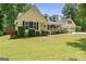 Charming yellow home featuring a lush front yard, covered porch, and an attached two car garage at 537 Country Lake Dr, Mcdonough, GA 30252