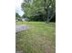 This grassy backyard features mature trees and a view of the neighborhood at 1932 Pharrs Rd, Snellville, GA 30078