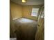 This bedroom features neutral walls and carpet, plus a window and closet at 1932 Pharrs Rd, Snellville, GA 30078